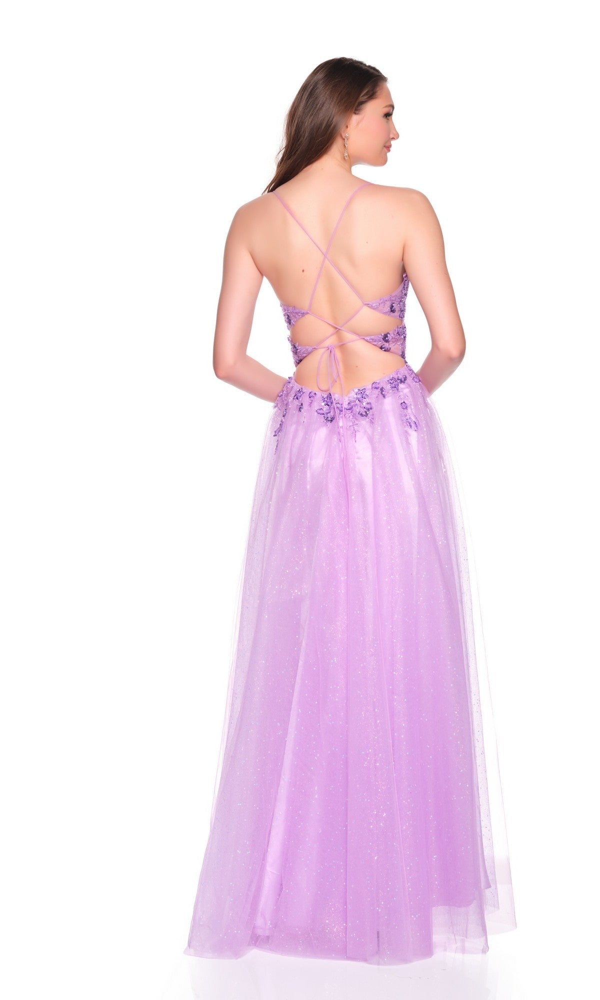 A woman stands against a white background wearing the Dave and Johnny 12883 long prom dressโa purple glitter tulle A-line gown with a backless design, crisscross straps, and an embroidered corset bodice featuring floral details.